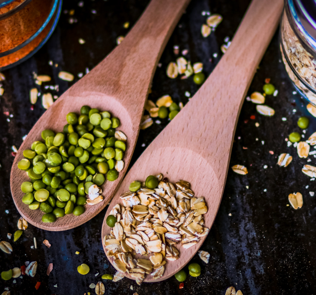 oats and peas on wooden spoon
